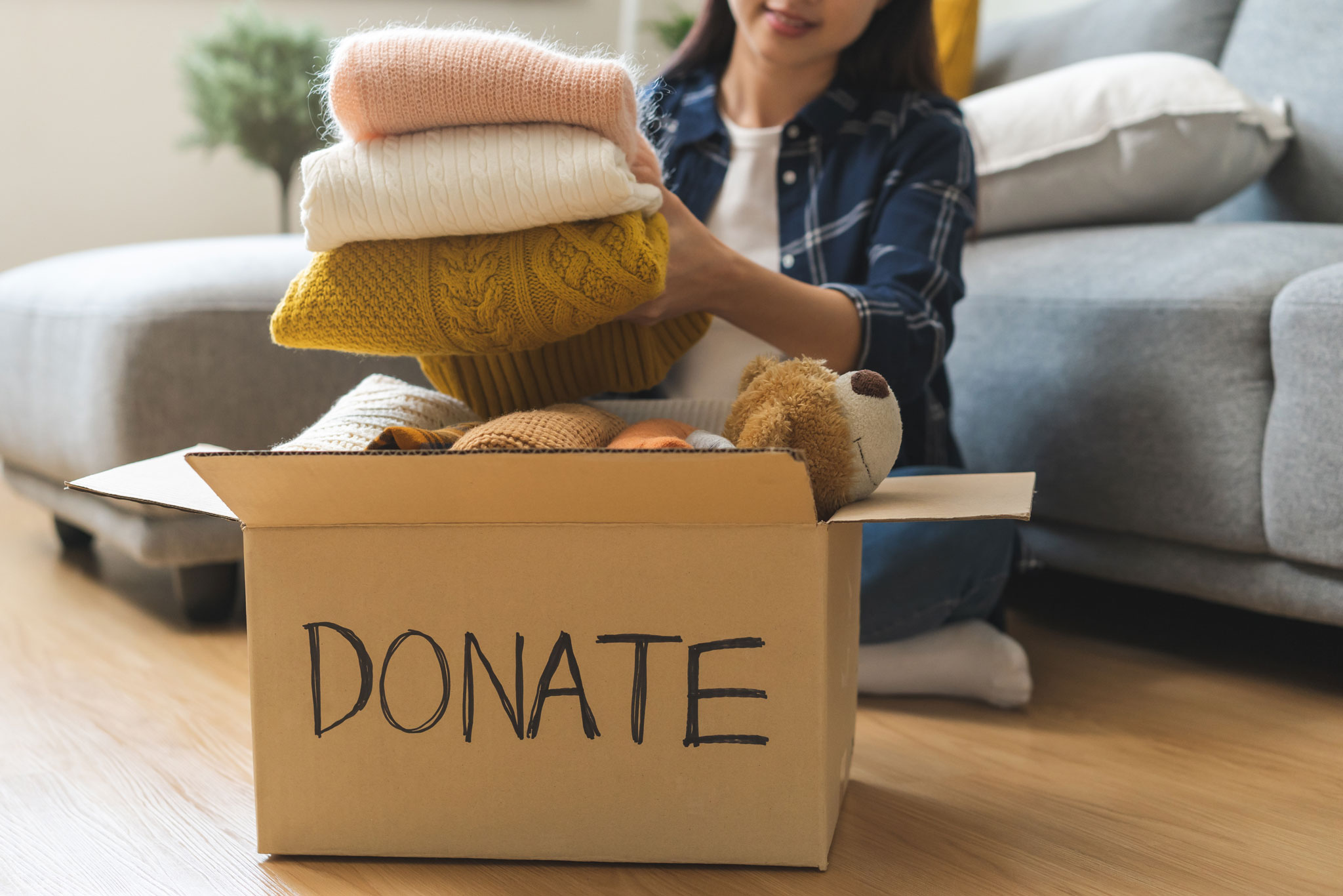 Woman filling a box marked 'Donate'.